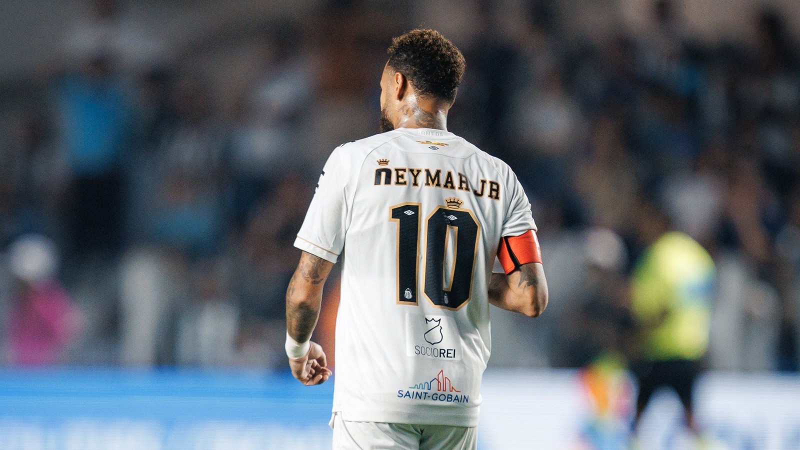 Neymar Jr de costas com camisa 10 branca do Santos e braçadeira de capitão laranja