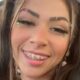 Jovem mulher sorrindo com cabelos longos, aparelho ortodôntico, maquiagem vibrante e piercing na sobrancelha