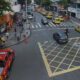 Vista aérea de rua movimentada com caminhão de bombeiros, táxis e pessoas no cruzamento