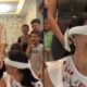 Jovem sorridente com buquê de flores e mulher vendada sorrindo em reencontro emocionante
