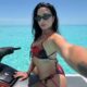 Demi Lovato de óculos escuros e biquíni floral em jet ski na água azul-turquesa das Bahamas