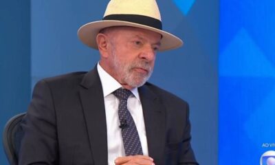 Lula de terno, gravata e chapéu de palha, em sabatina ao vivo na TV Globo, com fundo azul