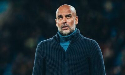 Pep Guardiola, careca e barbudo, em suéter azul escuro, com olhar pensativo