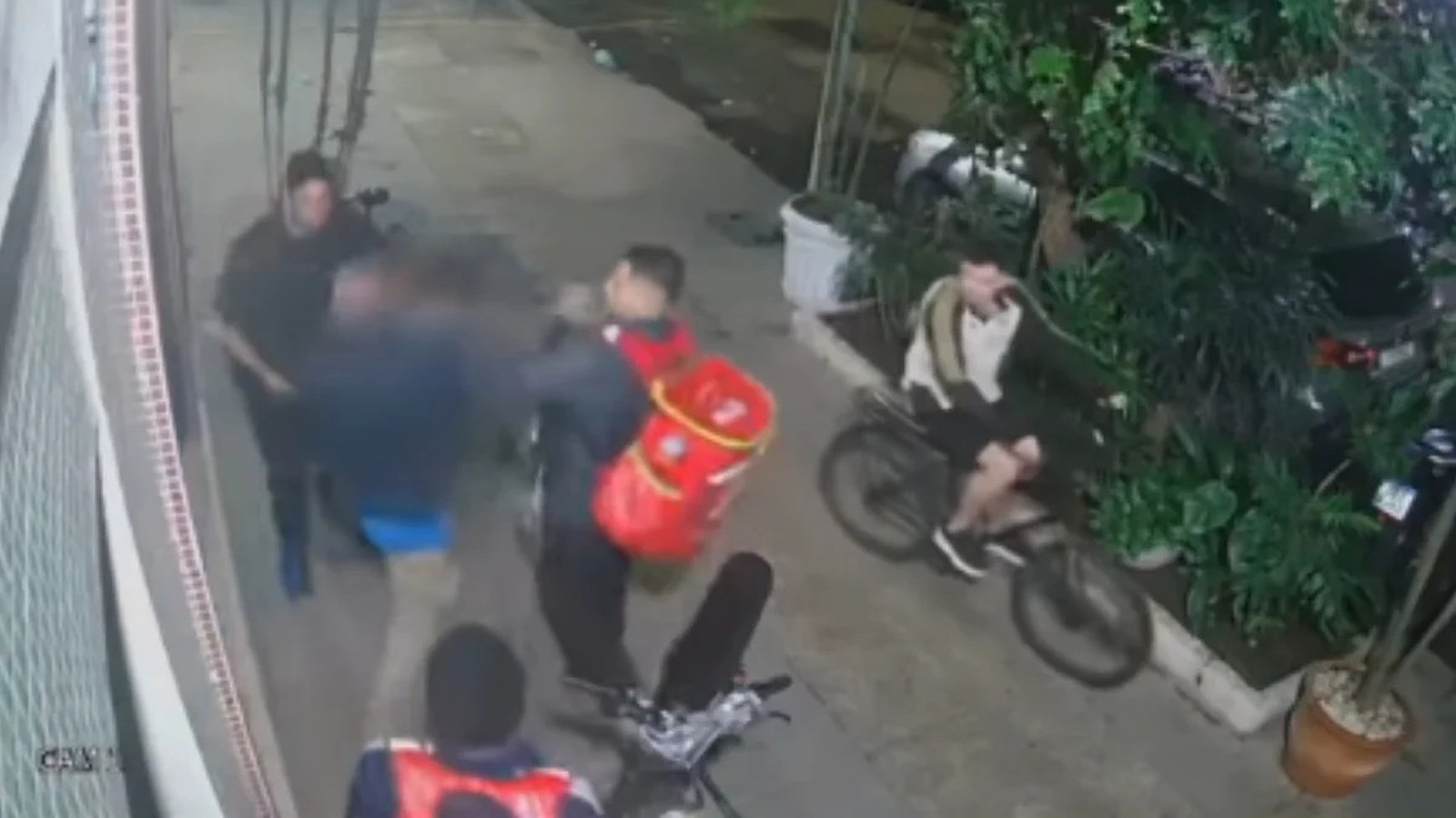 Gravação granulada de câmera de segurança mostrando pessoas durante uma briga na rua