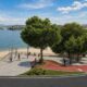Vista aérea de orla urbana com praia, baía, ciclovia vermelha, calçadão e pessoas
