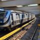 Trem moderno do MetrôRio parado em plataforma curva da estação Pavuna com pessoas ao fundo