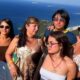 Grupo de seis pessoas sorrindo em selfie com vista panorâmica do Rio de Janeiro