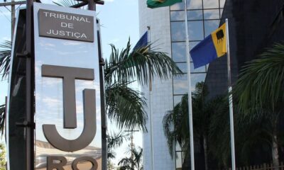 Sinal do Tribunal de Justiça com letras TJ, palmeiras e bandeiras do Brasil e Rondônia