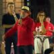 Lula, de camisa vermelha e chapéu, fala ao microfone em palco com outras pessoas