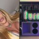 Mulher com óculos e tranças loiras, e neon escrito "furacão" sobre caixas de som