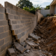 Morador usa o muro construído pelo vizinho para ampliar a área do quintal, a estrutura cede e o espaço precisa ser reconstruído