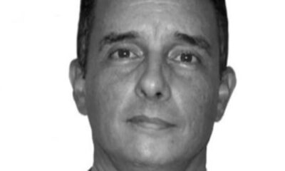 Retrato em preto e branco de homem de meia-idade olhando para frente com expressão neutra