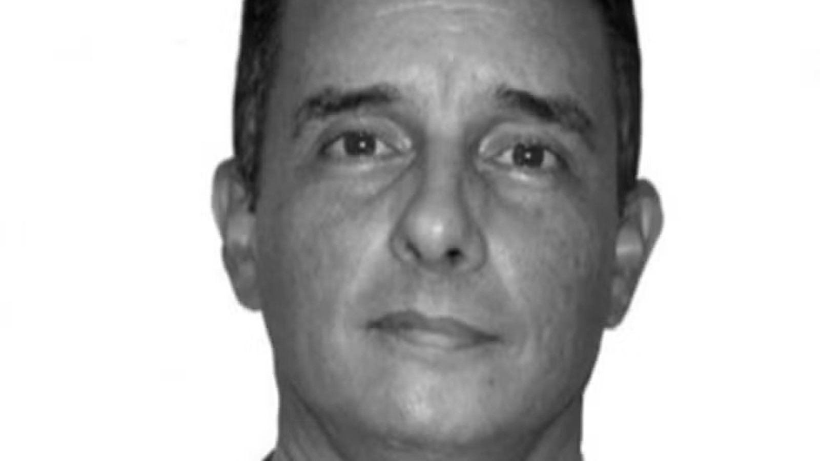 Retrato em preto e branco de homem de meia-idade olhando para frente com expressão neutra