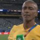 Homem de camisa amarela Romário com microfone verde em estádio, telão 'FIFA World Cup'