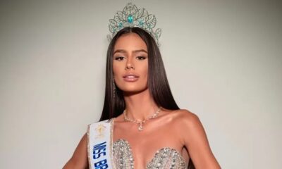 Mulher jovem com coroa, faixa de Miss Brasil e vestido brilhante posa para foto