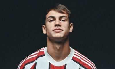 Retrato de homem jovem com cabelo escuro vestindo camisa listrada de futebol