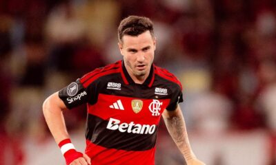 Saúl Níguez, jogador do Flamengo, em campo, camisa vermelha e preta, olhar sério