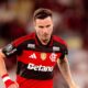 Saúl Níguez, jogador do Flamengo, em campo, camisa vermelha e preta, olhar sério