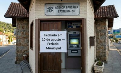 Agência bancária fechada em Castilho, com aviso de feriado municipal em 10 de agosto e caixa eletrônico disponível ao lado da entrada