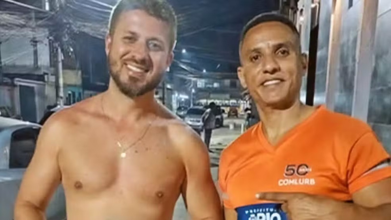 Dois homens sorrindo, um sem camisa e outro de camiseta laranja 5C Comlurb na rua
