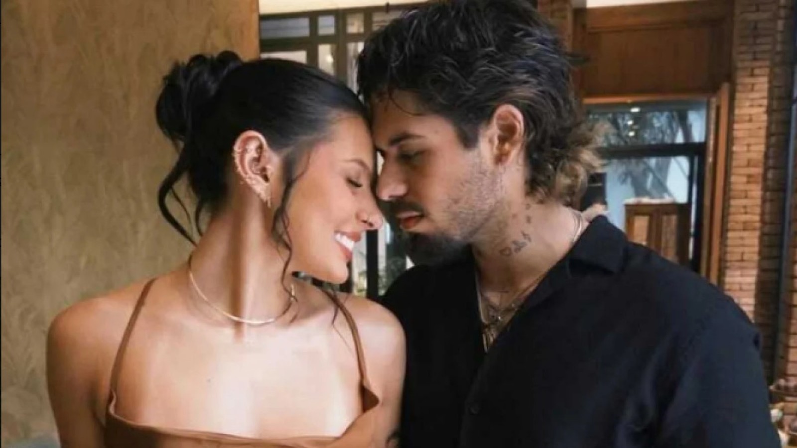 Um casal sorrindo se toca testa a testa em um momento de carinho e intimidade