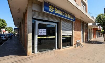 Fachada de agência bancária fechada em Catalão, com aviso de feriado municipal em 20 de agosto.