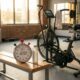 Cronômetro marcando 12 minutos ao lado de uma bicicleta ergométrica em academia, representando um treino curto de HIIT.