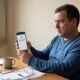 Homem sério olha para celular com app exibindo 'Pix Recebido R$ 8.000,00'