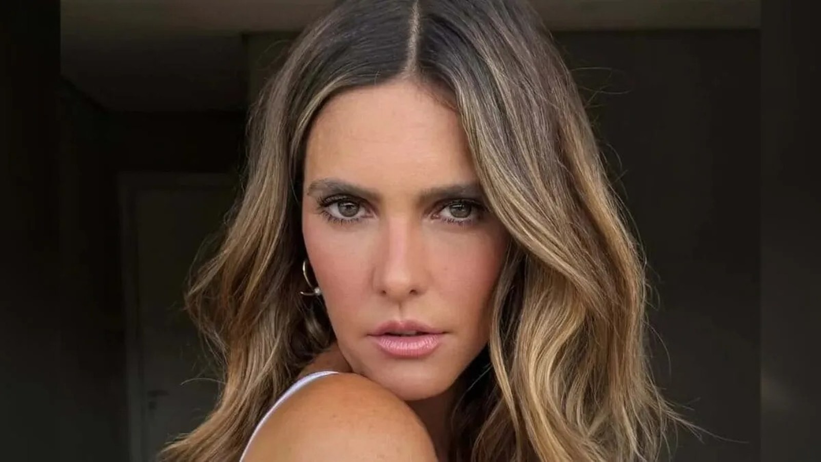 Close-up da apresentadora Fernanda Lima, cabelo ondulado com luzes, olhando fixamente