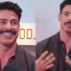 Cauã Reymond com bigode em podcast, sorrindo e gesticulando, fundo com logo "POD_i"