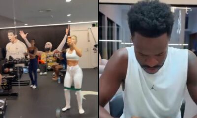 Academia movimentada com pessoas, recortes de atletas na parede e Vini Jr. em close, olhando para baixo