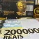 Notas decorativas de 1.000.000 e 2.000.000 Reais, logo Cardano, e estatueta de águia