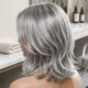 Cabelo feminino grisalho prateado em corte long bob com camadas suaves e movimento natural.