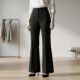 Calça flare preta de cintura alta combinada com camisa branca e sapato de salto discreto, formando um look feminino elegante e de silhueta alongada