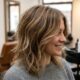 Cabelo feminino de comprimento médio com corte shaggy, camadas suaves, volume natural e pontas com movimento em um salão de beleza