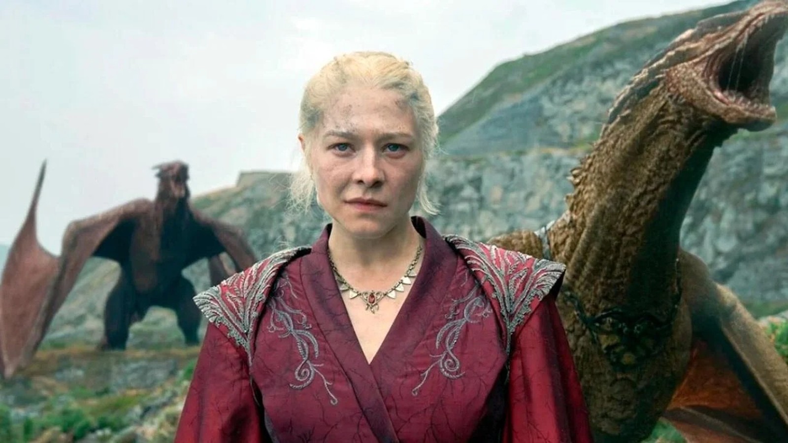 Emma D'Arcy como Rhaenyra Targaryen em traje vermelho com dois dragões ao fundo