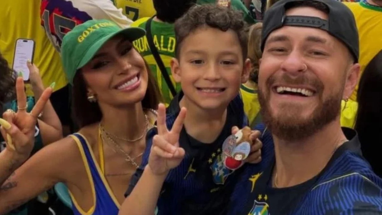 Selfie: mulher de boné GOXT, menino e homem barbudo de boné preto fazem sinal de paz