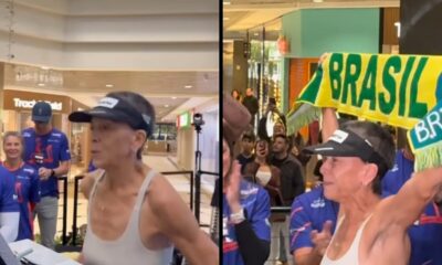 Mulher de regata branca e viseira na esteira e comemorando recorde com faixa Brasil