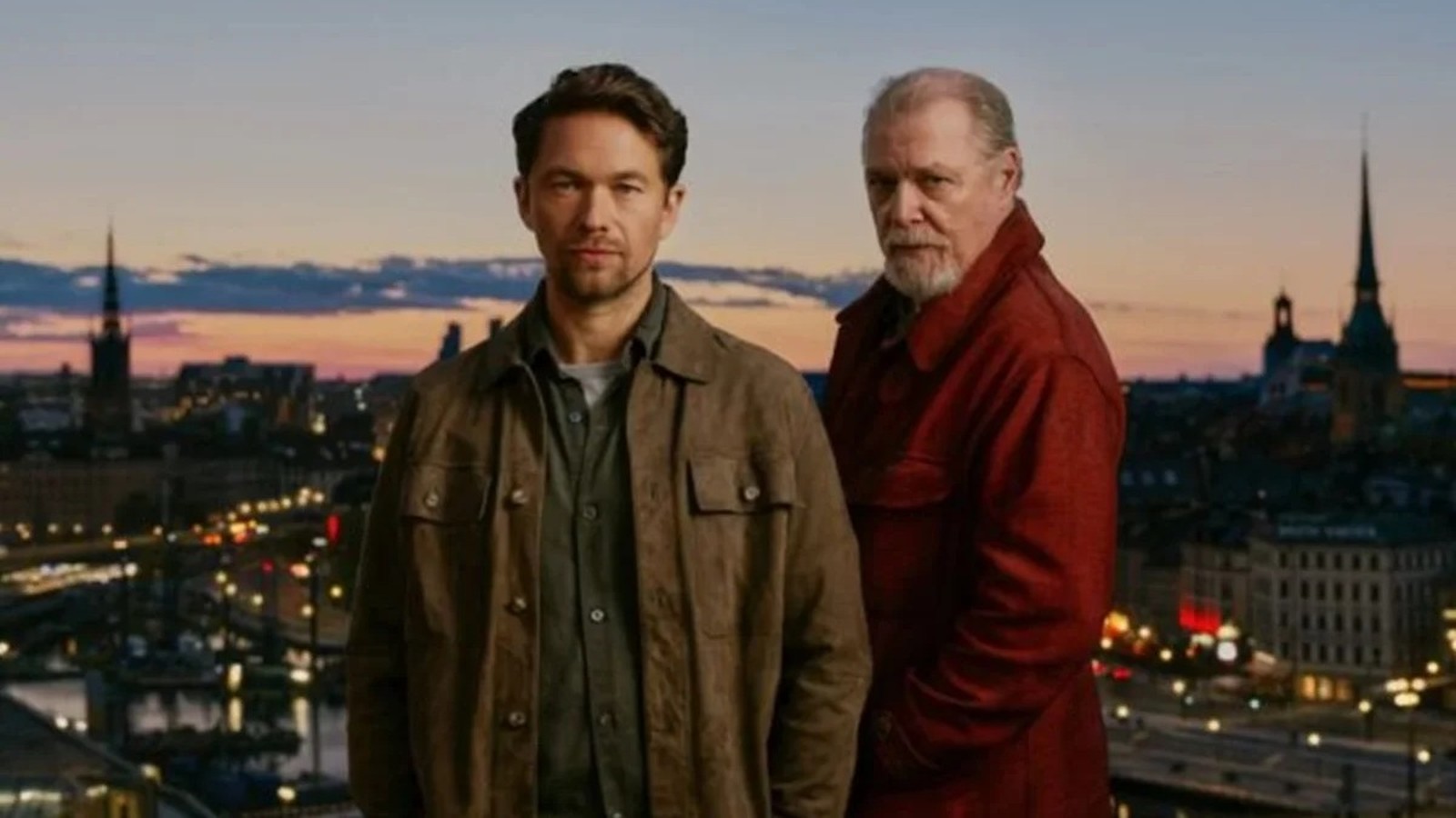Atores Jakob Oftebro e Peter Andersson em frente à paisagem urbana de Estocolmo ao anoitecer