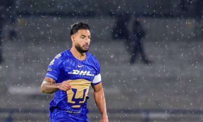 Nathan Silva, jogador do Pumas, em campo com camisa azul sob chuva leve.