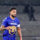 Nathan Silva, jogador do Pumas, em campo com camisa azul sob chuva leve.
