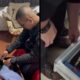 Homem de camisa escura revistando gavetas com roupas dobradas em uma residência