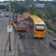 Ônibus amarelo, caminhão de bombeiros vermelho e moto caída no asfalto com cones de trânsito