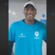 Professor Carlos Eduardo Cerqueira sorri com camiseta azul Maniacs World Cup e boné branco