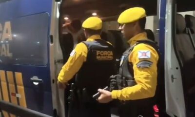 Agentes da Força Municipal com colete 'FORÇA MUNICIPAL' ao lado de van policial