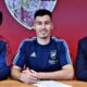 Mikel Arteta, Gabriel Martinelli e Edu Gaspar sorrindo enquanto Martinelli assina contrato pelo Arsenal