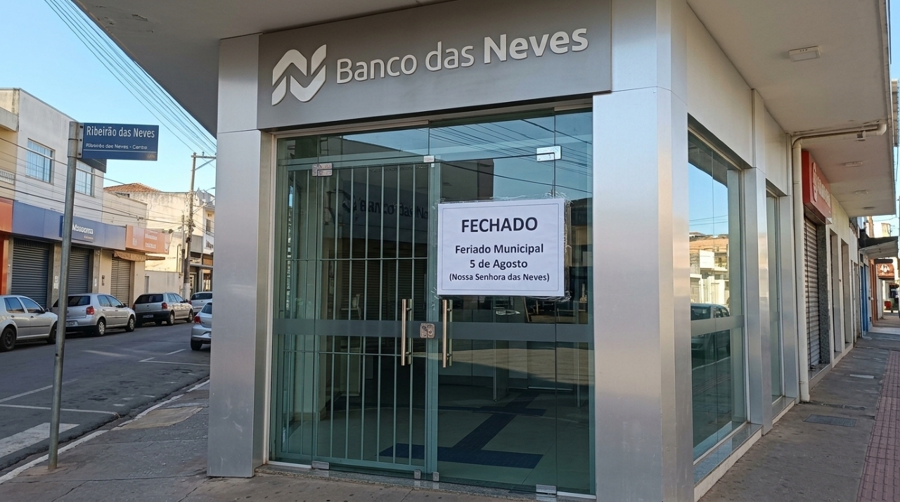 Fachada de agência bancária fechada com aviso de feriado municipal em 5 de agosto, dia de Nossa Senhora das Neves, em Ribeirão das Neves