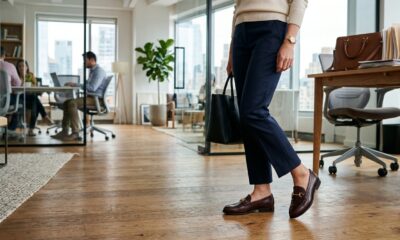 Mulher usando mocassim feminino com calça de alfaiataria em escritório moderno.
