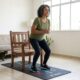 Mulher com mais de 50 anos levantando-se de uma cadeira firme durante treino de força em casa