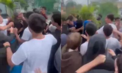 Aglomerado de jovens em confronto físico com um homem mais velho, ao ar livre